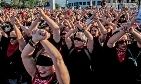Stor folkmassa i svart kläder gör samordnade rörelser under en protest