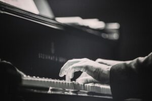 Närbild av händer som spelar piano i svartvitt