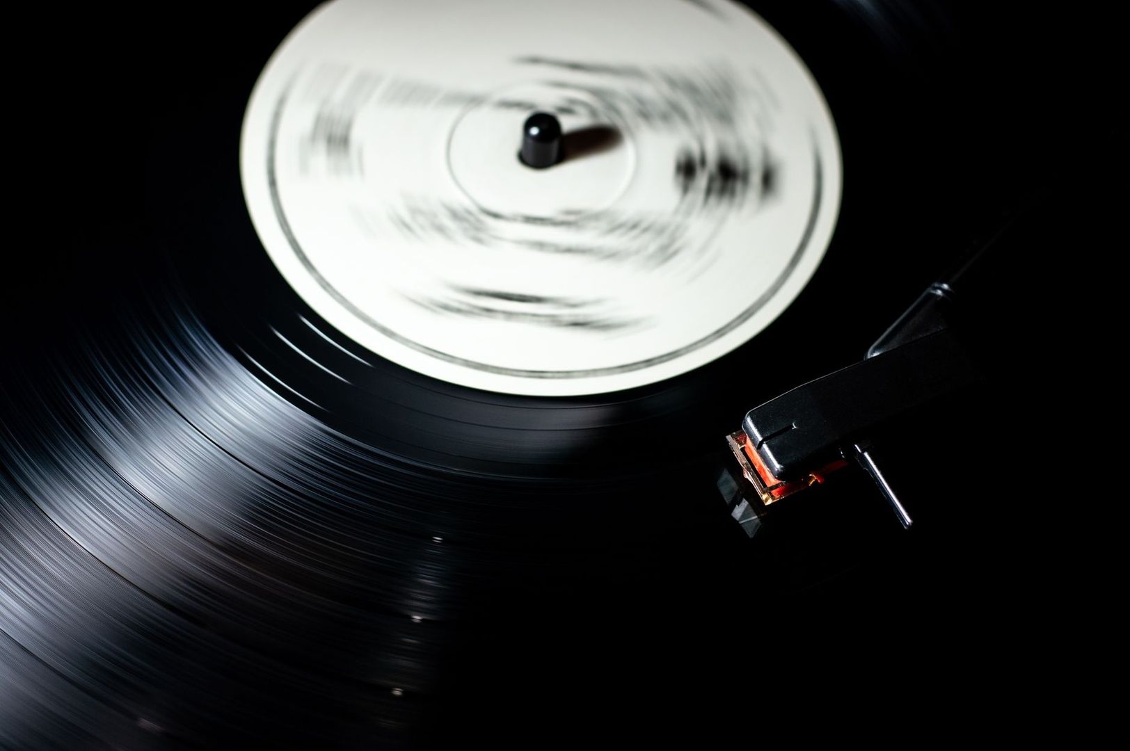 Närbild av en snurrande vinylskiva med pickup på en skivspelare